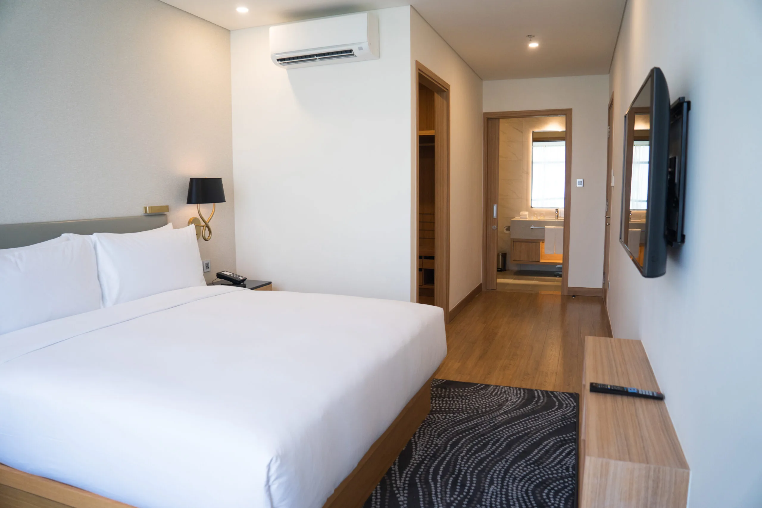 Clean hotel room interior with double bed and bathroom